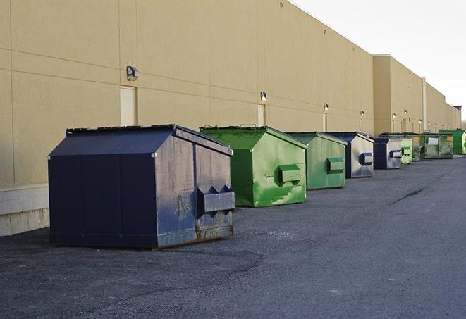 a waste management truck unloading into a construction dumpster in Connell, WA